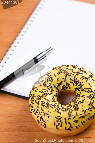 Image of sweet doughnut and spiral notebook