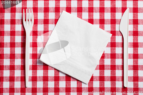 Image of plastic cutlery on checkered tablecloth