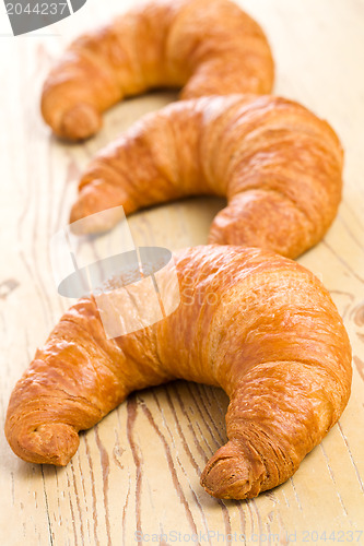 Image of fresh croissant on wooden table