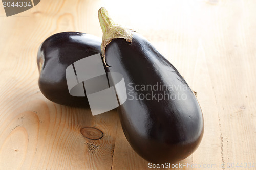 Image of two eggplants on wooden table