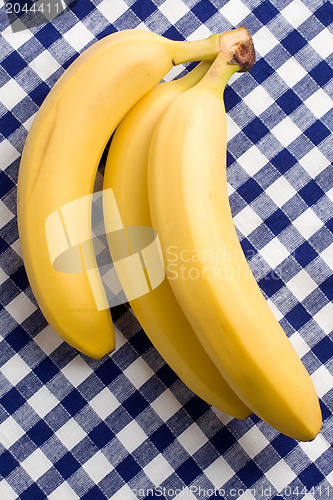 Image of yellow bananas on checkered tablecloth