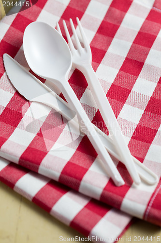 Image of plastic cutlery on checkered tablecloth