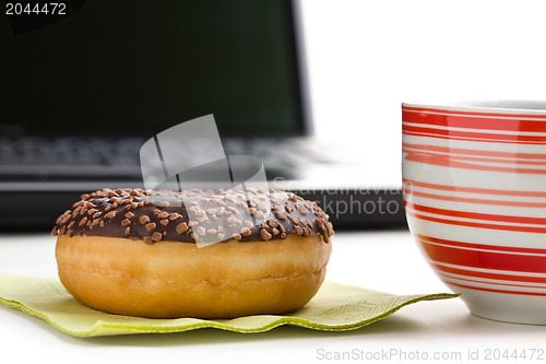 Image of break in the  office . doughnut on laptop keyboard