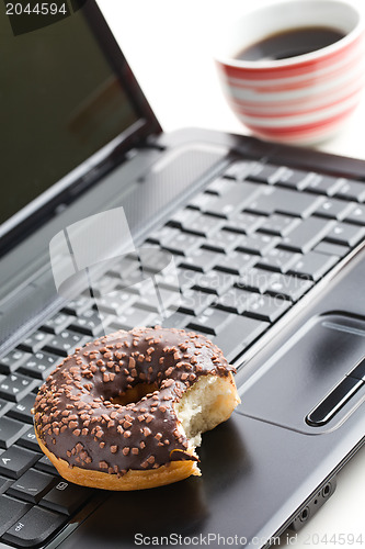 Image of break in the  office . doughnut on laptop keyboard