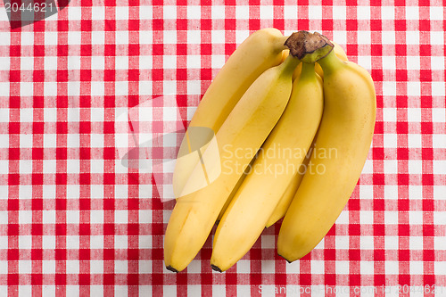 Image of yellow bananas on checkered tablecloth