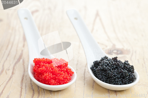 Image of red and black caviar in ceramic spoon