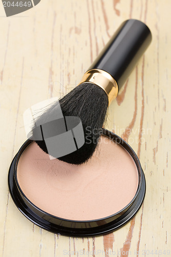 Image of makeup brush and cosmetic powder compact 