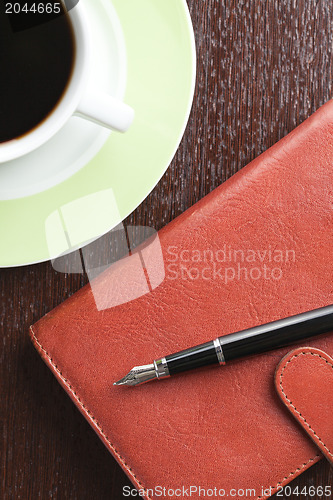 Image of pen on diary and coffee mug