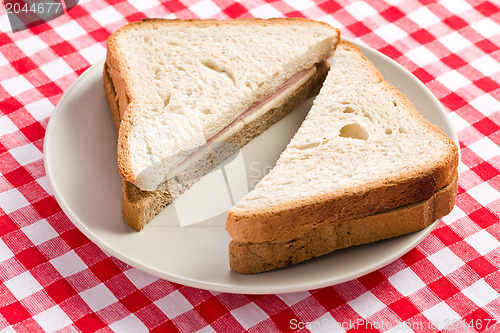 Image of ham sandwich on checkered tablecloth