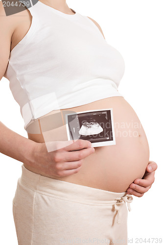Image of pregnant woman is holding a photo of her Ultrasound