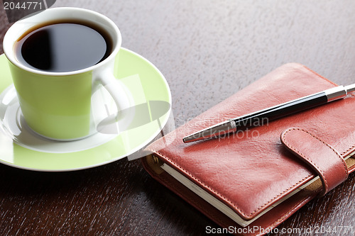 Image of pen on diary and coffee mug