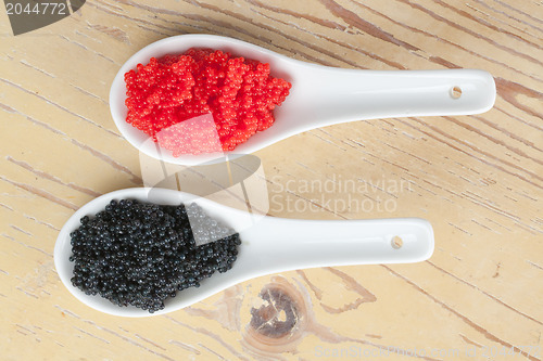 Image of red and black caviar in ceramic spoon