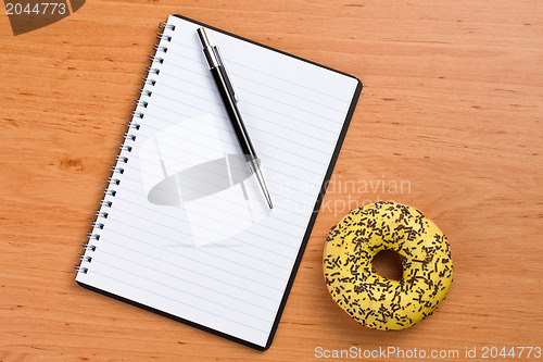 Image of sweet doughnut and spiral notebook