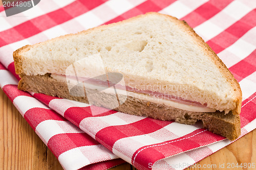 Image of ham sandwich on checkered napkin