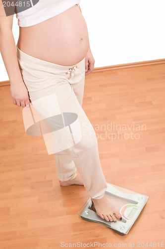 Image of pregnant woman standing on scales