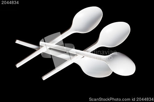 Image of plastic spoons on black background