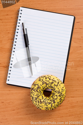 Image of sweet doughnut and spiral notebook