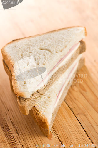 Image of ham sandwich on wooden table 