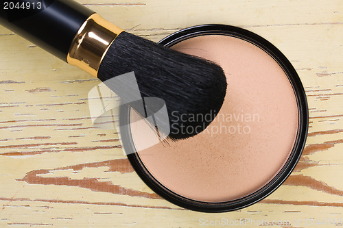 Image of makeup brush and cosmetic powder compact 