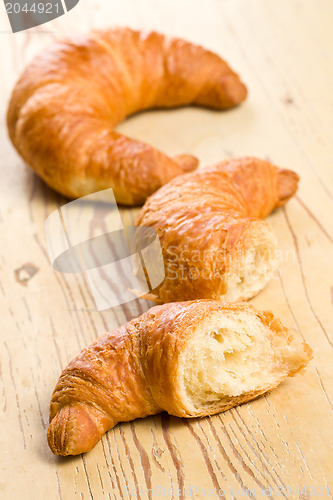 Image of fresh croissant on wooden table