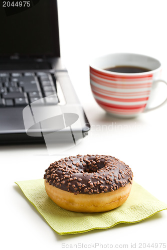 Image of break in the  office . doughnut on laptop keyboard