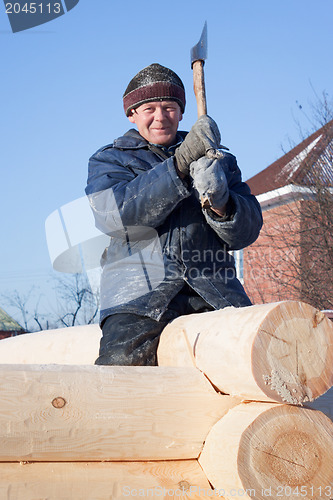 Image of Man builds a wooden house