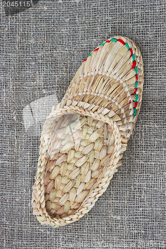 Image of Wicker bast shoe on linen fabric