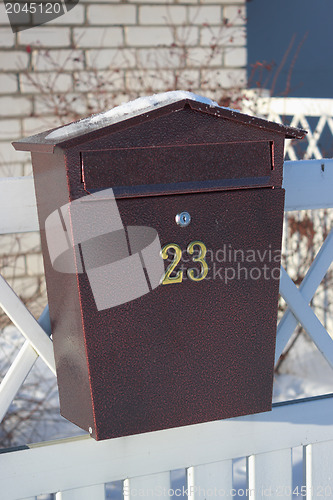 Image of Mailbox hanging on a white fence