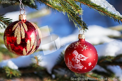 Image of christmas balls on outdoor snowy tree