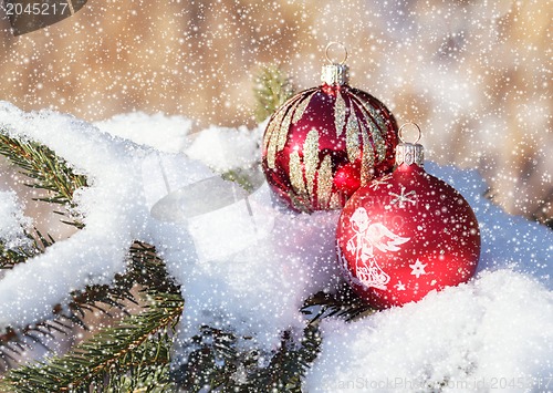 Image of christmas balls on snowy day outdoor