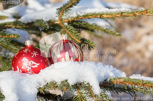 Image of christmas balls on outdoor snowy tree