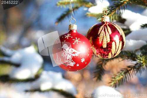 Image of christmas balls on outdoor snowy tree