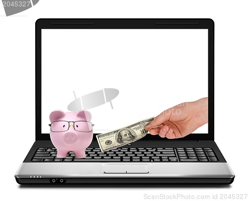 Image of Conceptual image of piggy bank, dollars and laptop
