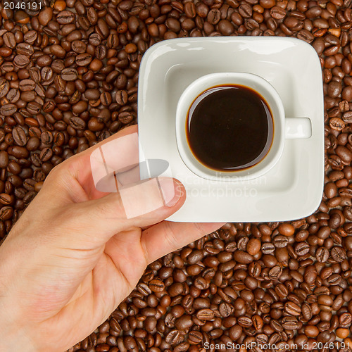 Image of Cup of coffee on beans. top view