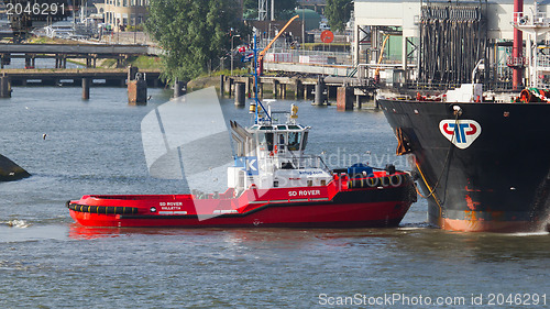 Image of Two tugboats manoeuvring an oil tanker in the dutch harbor of Ro