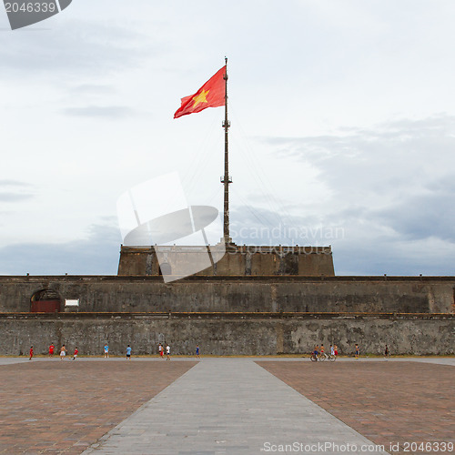 Image of HUE, VIETNAM - AUG 4: Boys playing football in front of the Flag