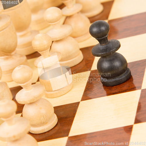 Image of Black pawn on a wooden chessboard