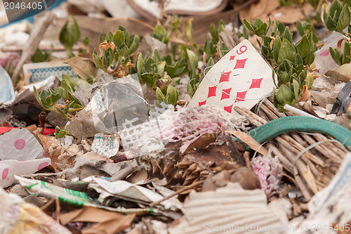 Image of Old playing card on a pile of garbage