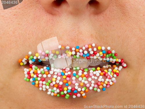 Image of Woman lips with multicolored pearls 