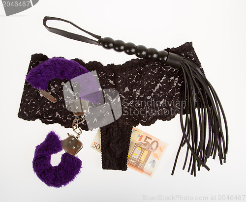 Image of Fluffy purple handcuffs, a whip, money and panties, prostitution