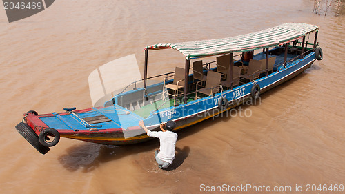 Image of MEKONG DELTA, VIETNAM, 12 AUGUST 2012 - Tourist guide pushes a b