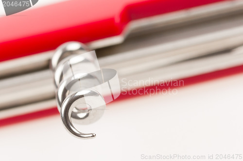 Image of Red swiss army knife isolated, focus on corkscrew