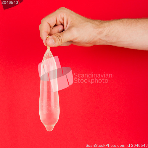 Image of White condom with water in hand