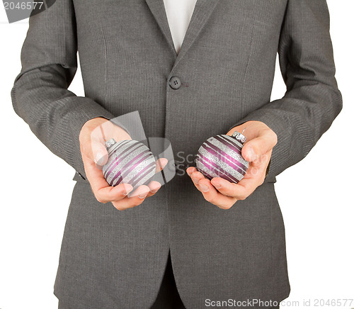 Image of Man in grey suit is holding Christmass balls