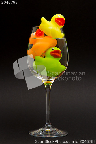 Image of Yellow, orange and green rubber duck in a wineglass