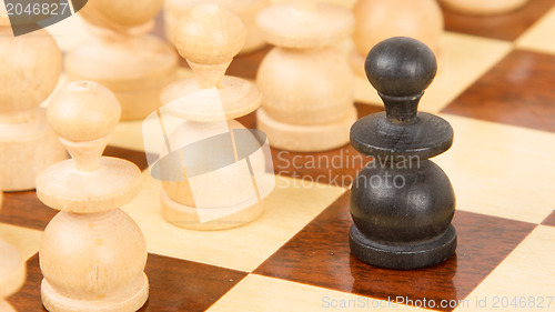 Image of Black pawn on a wooden chessboard