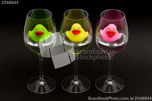 Image of Green, yellow and pink rubber ducks in wineglasses