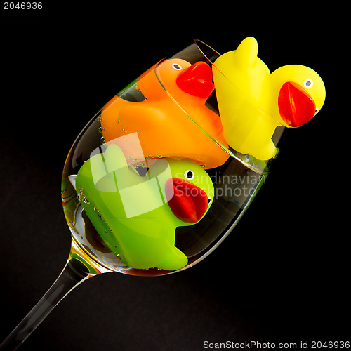 Image of Yellow, orange and green rubber duck in a wineglass