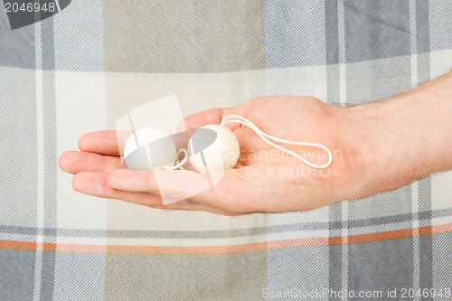 Image of Hand holding white vaginal balls, isolated