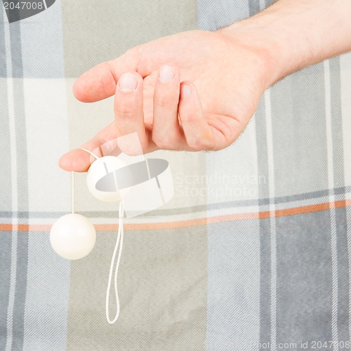 Image of Hand holding white vaginal balls, isolated